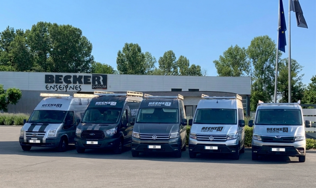 Tos les vehicules de becker publiicte sont stationnés devant l'entrepôt becker et ils sont tous marqués au logo de l'entreprise. Covering de flotte