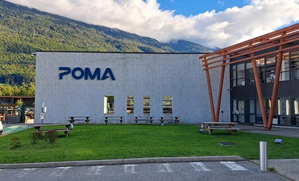 Signalétique extérieure d'entreprise en lettres découpées bleues installée sur la façade blanche du bâtiment Poma.